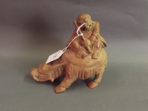 A Chinese carved bamboo figure of an old man seated on a water buffalo, 6½'' high