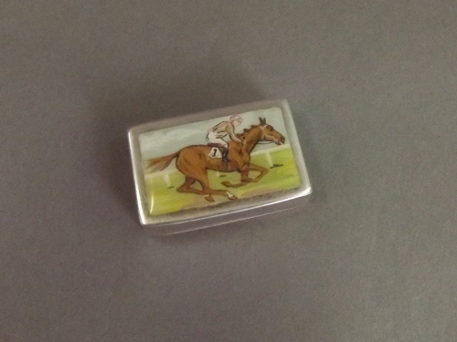 A Hallmarked silver pill box, the enamel top painted with a racehorse with jockey up, Chester 1910/