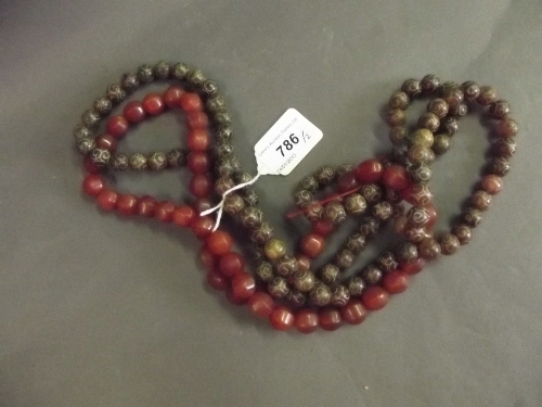 A carved jade beaded necklace, and another