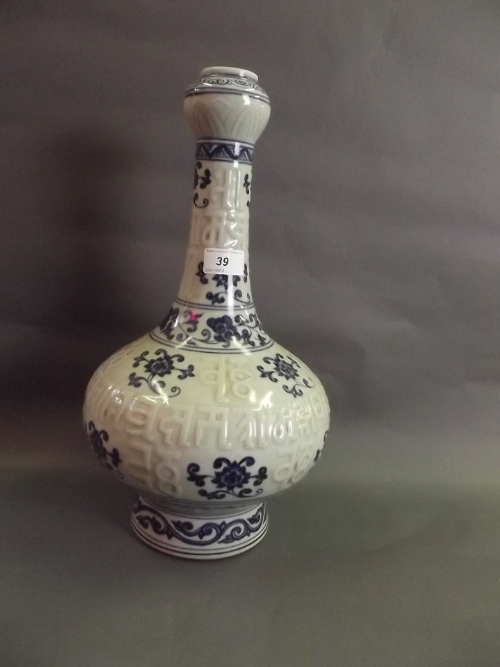A Chinese celadon glazed porcelain vase with relief decoration of Tibetan script and blue and