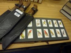 Three reproduction knives and cigarette cards in one album