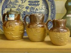 Three graduated stoneware hunting jugs, late 19th/ early 20th Century, two stamped Doulton