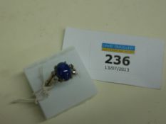 Ring set with blue cabochon stone and four diamonds stamped 18k