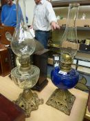 Victorian oil lamp with Bristol blue glass reservoir on cast metal base and a similar lamp with