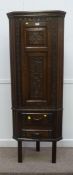 Early 20th Century medium oak floor standing corner cabinet, carved panelled door