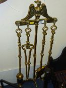 Four piece brass companion set on stand surmounted by an eagle