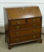 George III oak bureau of two short and three long drawers, fall front opening to reveal well