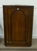 Early George III oak corner cabinet, three shaped shelves enclosed by fielded panel door