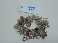 Hallmarked silver chain bracelet with large quantity of charms and threepenny pieces
