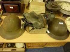Two WWII helmets standard and tropical issues and gas mask in original box