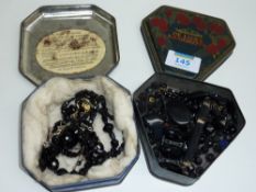 Victorian French jet necklaces, brooches and beads in two vintage tins