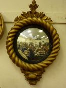 Regency period convex mirror in gilded rope twist frame with foliate pediment