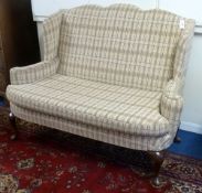 Early 20th Century Queen Anne style upholstered wing back settee with carved walnut supports