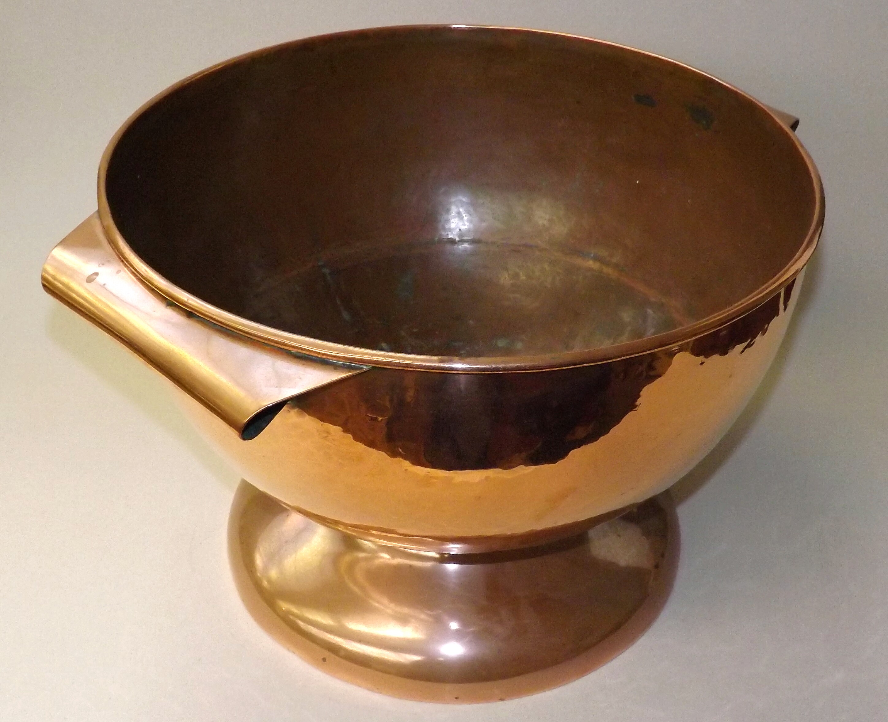 A large copper twin-handled pedestal bowl, diameter 39cm.