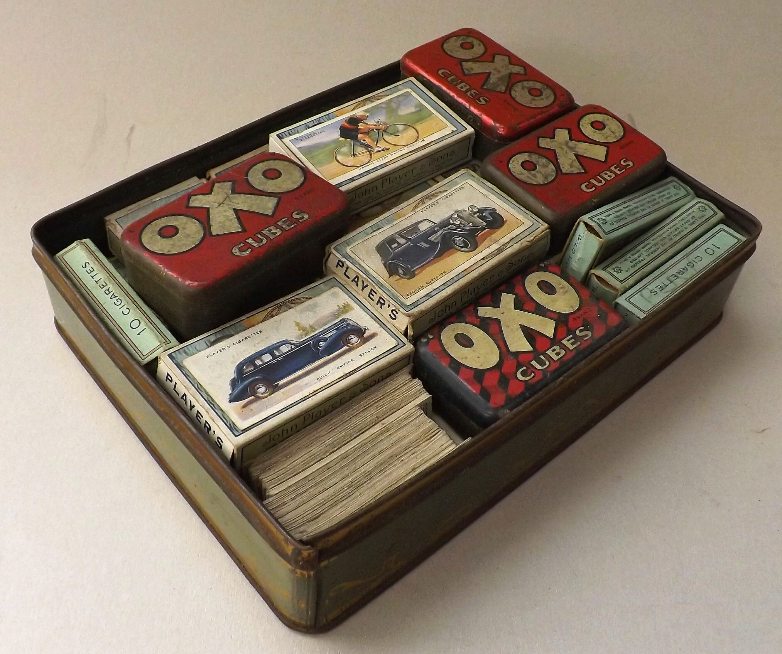 A quantity of cigarette cards in cigarette boxes and Oxo tins.