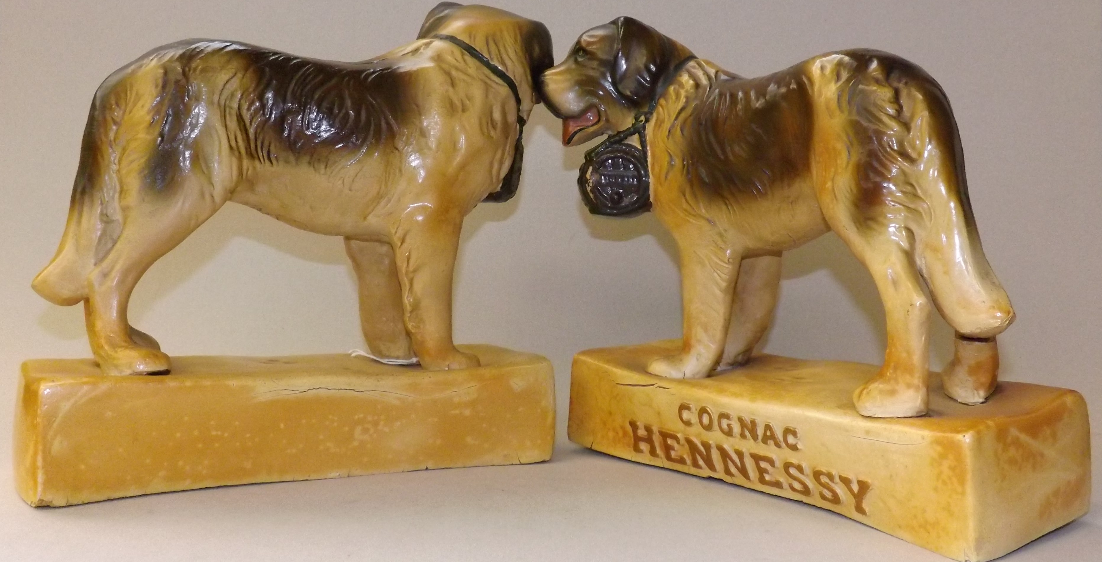 A pair of 1930's Hennessy cognac, advertising, composition painted St Bernard dogs, height 24cm.