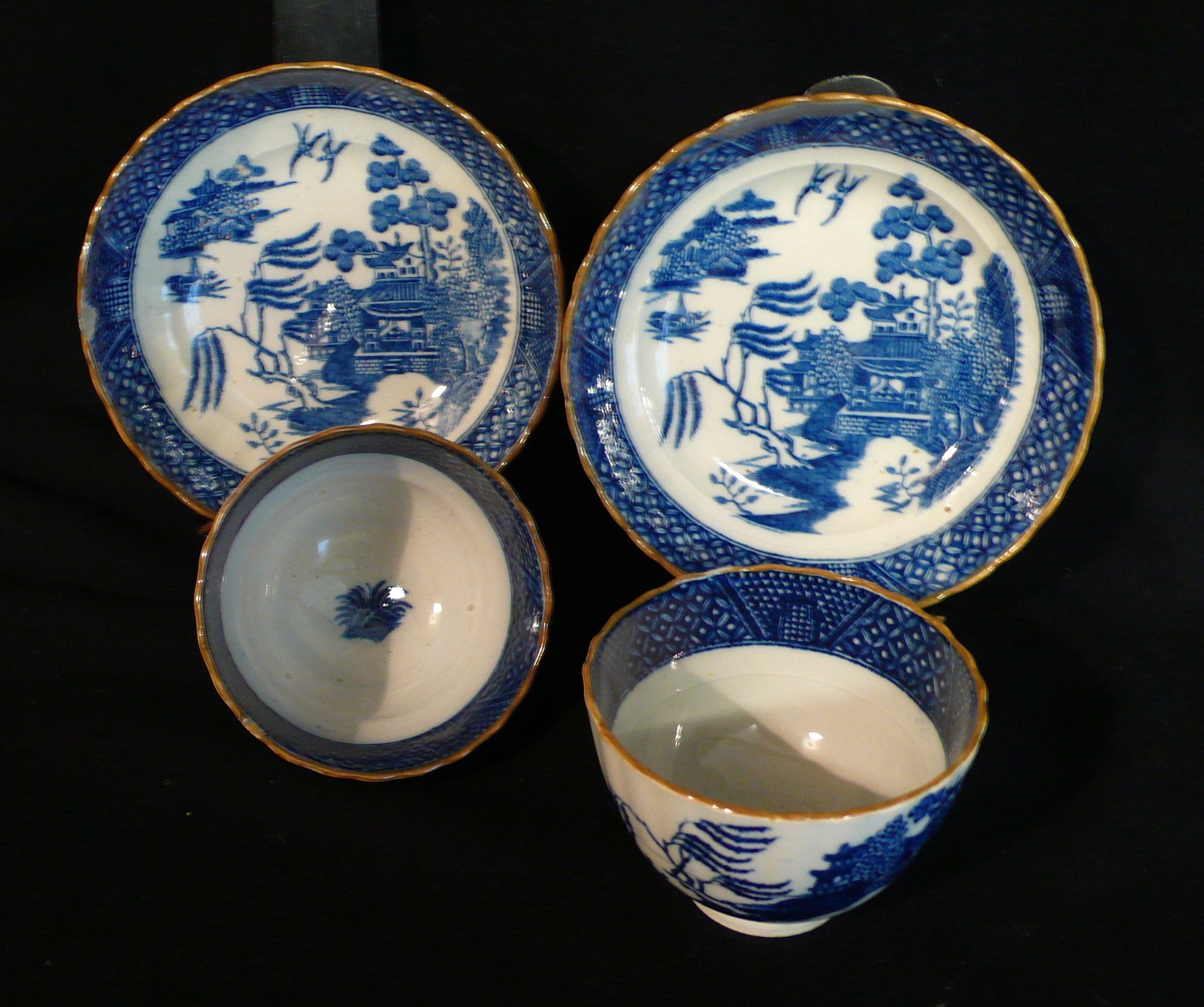 A pair of fluted tea bowls and saucers, c1800, printed in deep blue “The Willow” pattern with