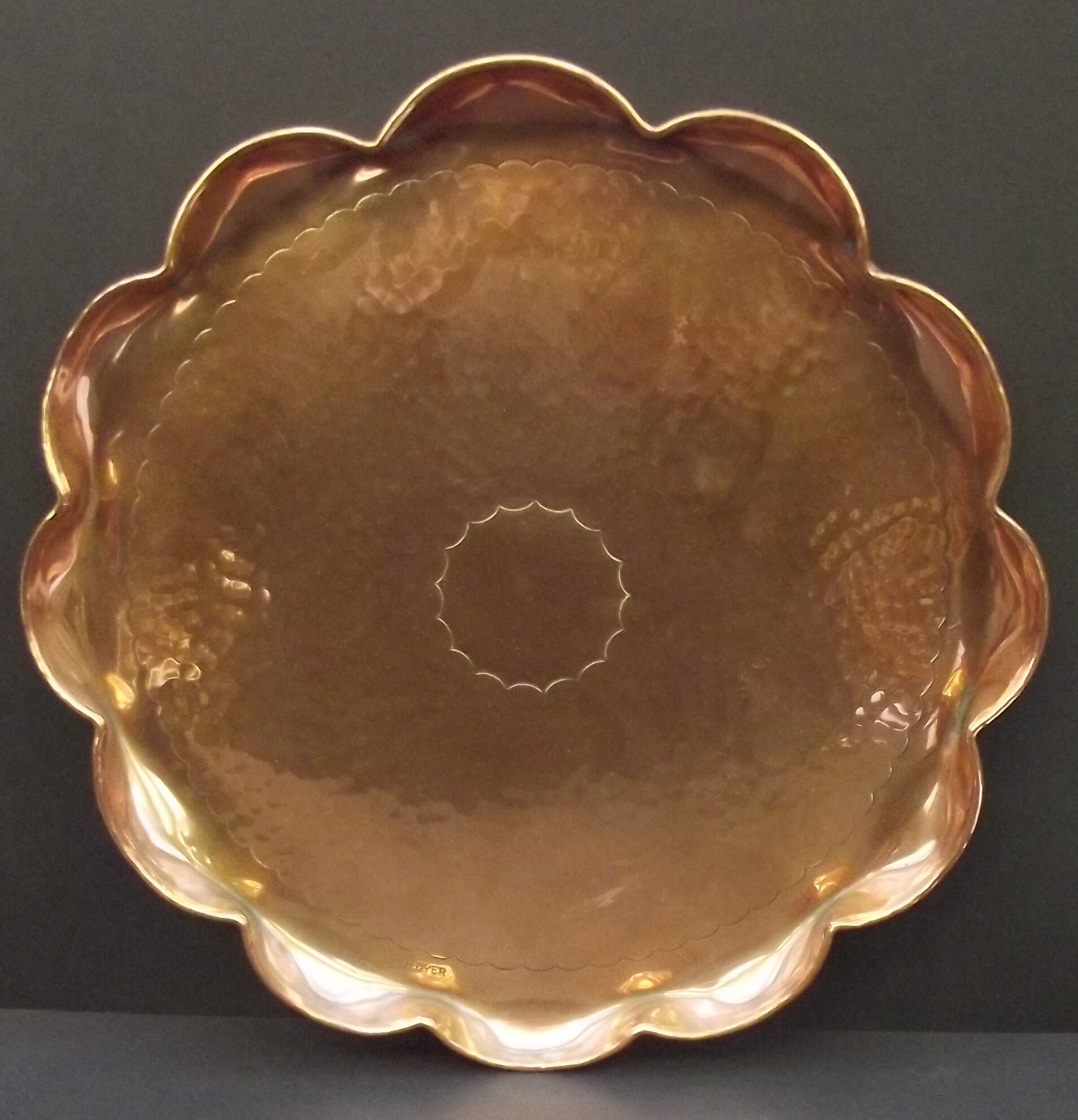 Herbert Dyer, lobed rim circular copper tray with planished decoration, stamped mark, diameter