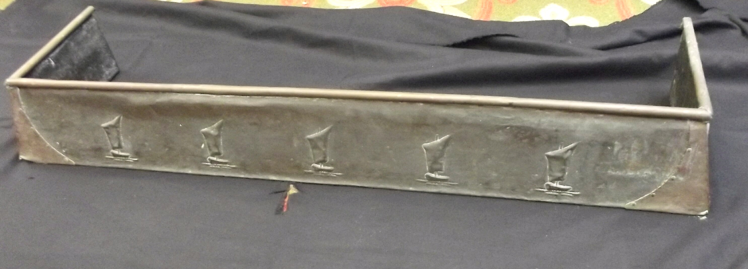 A copper Arts and Crafts fender embossed with boats, width 109cm.