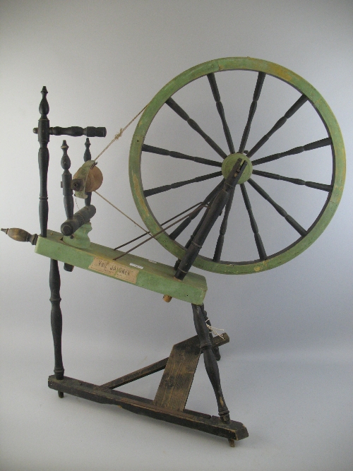 A Scandinavian spinning wheel, the ebonised and green painted frame with turned supports and