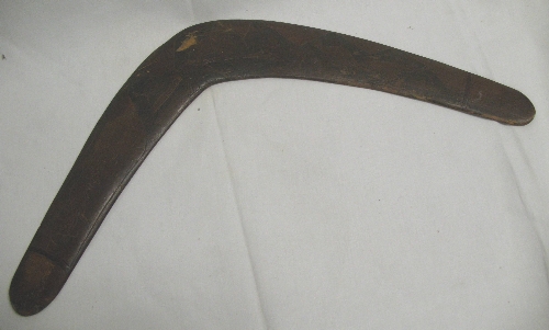 An Australian boomerang, carved from the solid with kangaroos and kookaburra`s in a mountainous