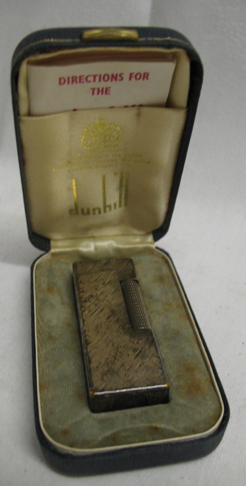 A Dunhill silver plated pocket lighter, of engine turned oblong form with roller action, in original