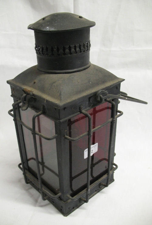 A black painted steel lantern, of square section with caged sides, swing handle and alternate