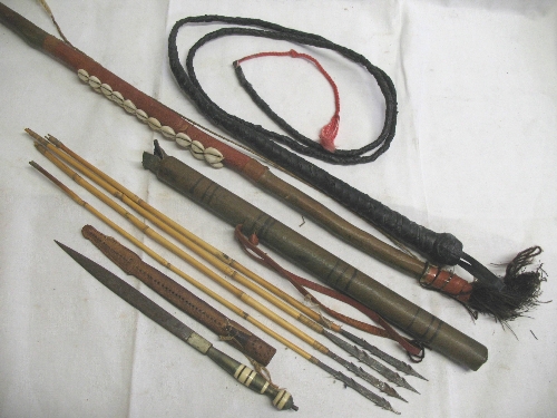A native wooden bow, of slightly curving form covered in leather and mounted with cowrie shells,
