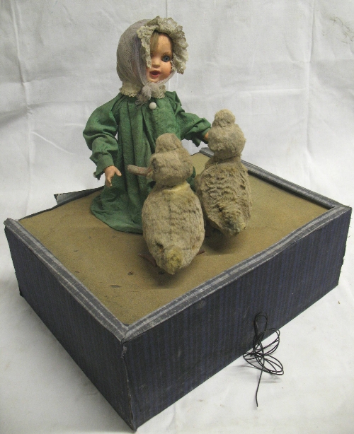 A 12v electrically operated automatum doll, of a young girl with composition head and lower arms