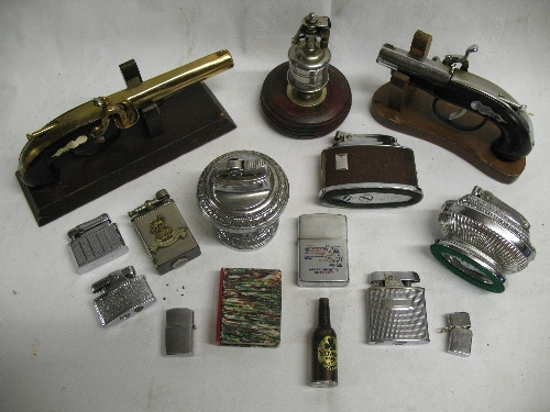 A collection of fifteen petrol pocket and table lighters, including two pistols on stands, World War