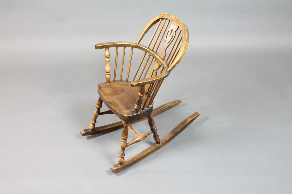 An early 20th Century childs high back Windsor rocking chair  with pierced and shaped vase splat,