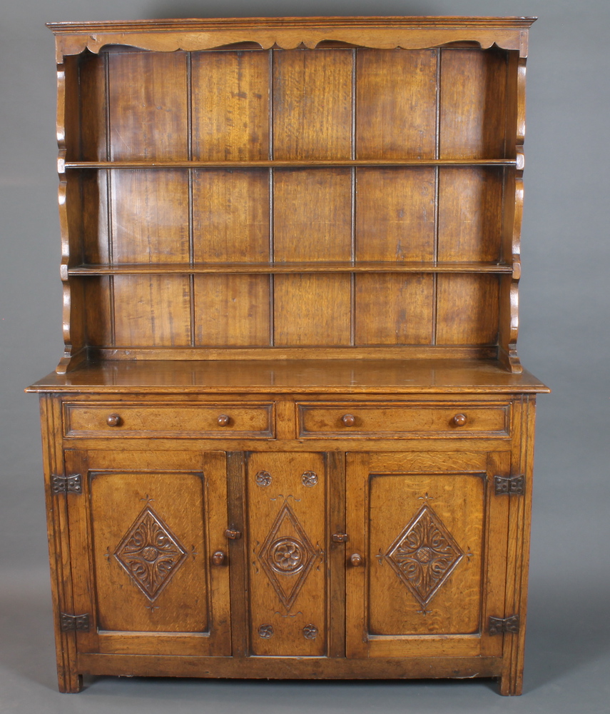 A mid 18th Century style oak high back dresser having a shaped  cornice above a 2 shelf panelled