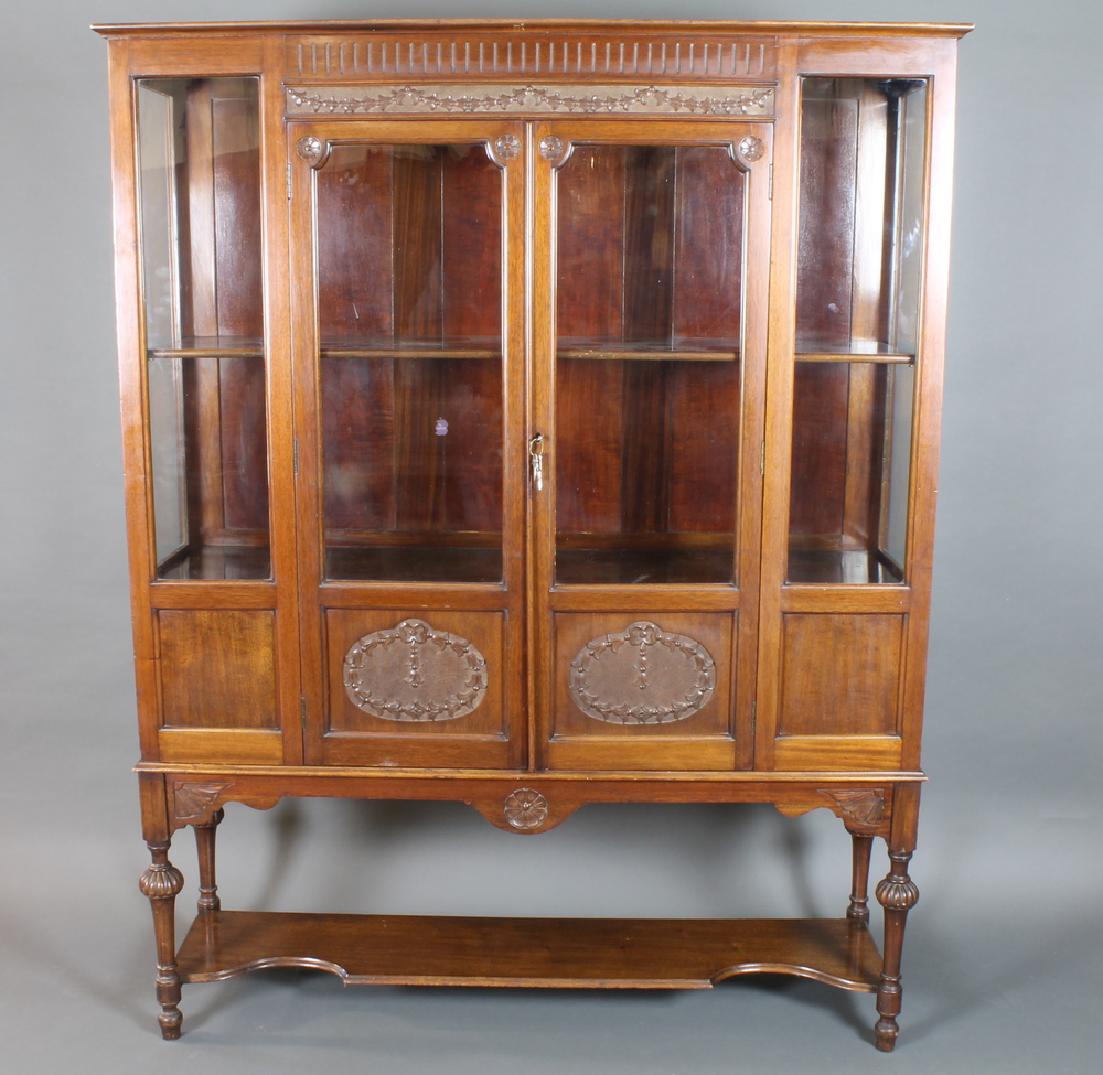 A late Victorian mahogany display cabinet in the Sheraton style, having fluted cornice above a