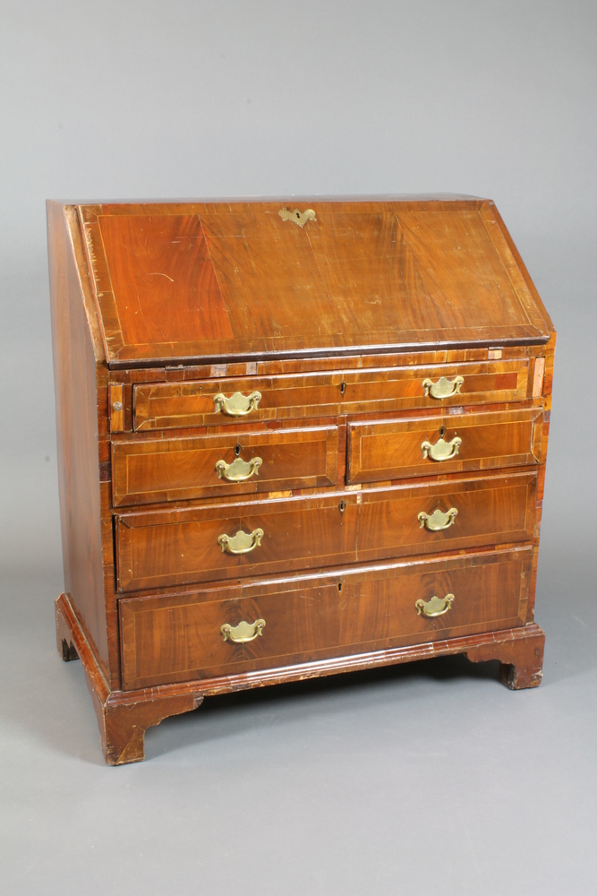 A Georgian mahogany bureau, crossbanded, the fall enclosing a  fitted interior above 2 short and 3