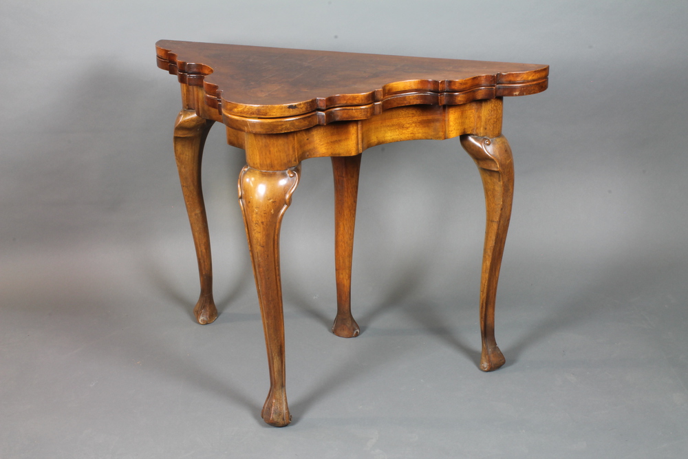 An early 20th Century burr walnut tea table in the Queen Anne  style, crossbanded with hinged top