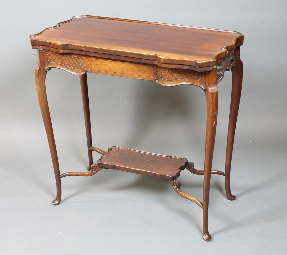 A 1920`s mahogany card table in the French taste, the hinged top enclosing a baise lined interior