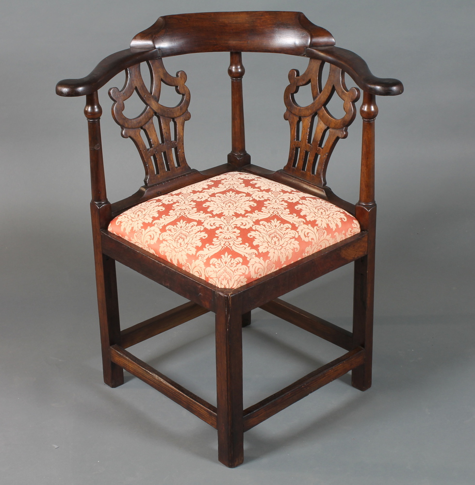 A George III mahogany smoker`s bow corner chair with scroll cresting rail, shaped and pierced splats