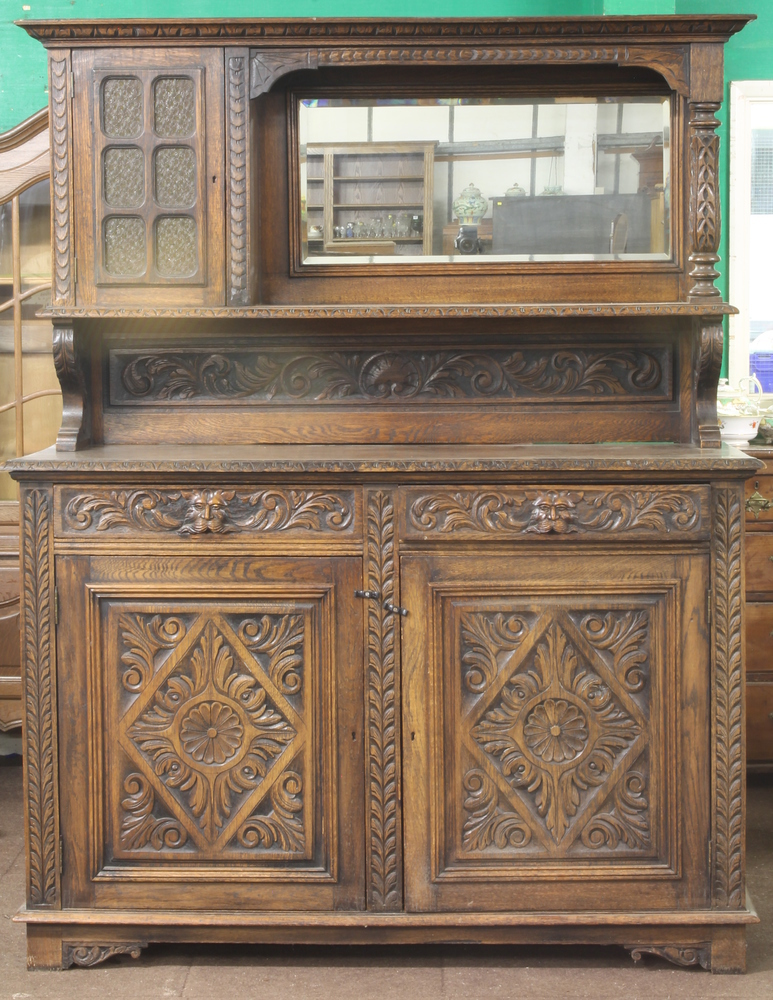 A Victorian carved oak sideboard, the raised back with moulded cornice, fitted a mirror and