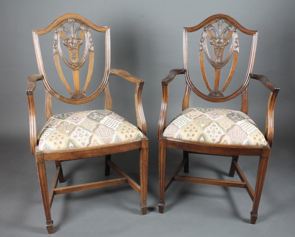 A pair of mahogany Hepplewhite style carver chairs with  upholstered drop in seats, raised on square