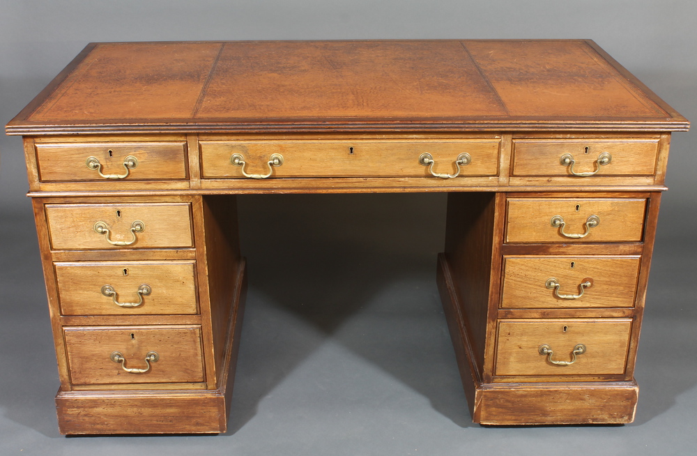 An Edwardian mahogany kneehole pedestal desk with inset tooled writing surface above 1 long and 8