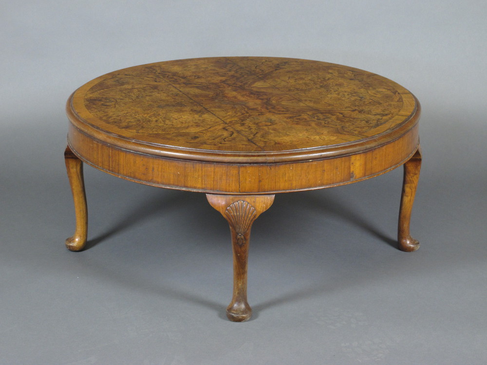 A circular figured walnut coffee table with crossbanded top,  raised on cabriole supports 33"w x
