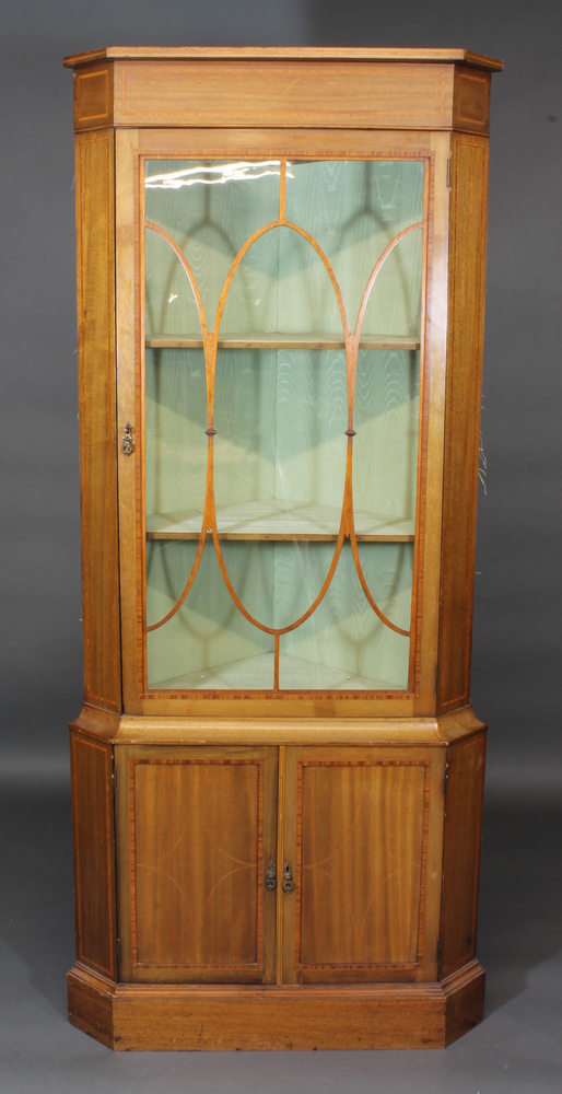 A 19th Century inlaid mahogany double corner cabinet with  moulded cornice, the upper section fitted