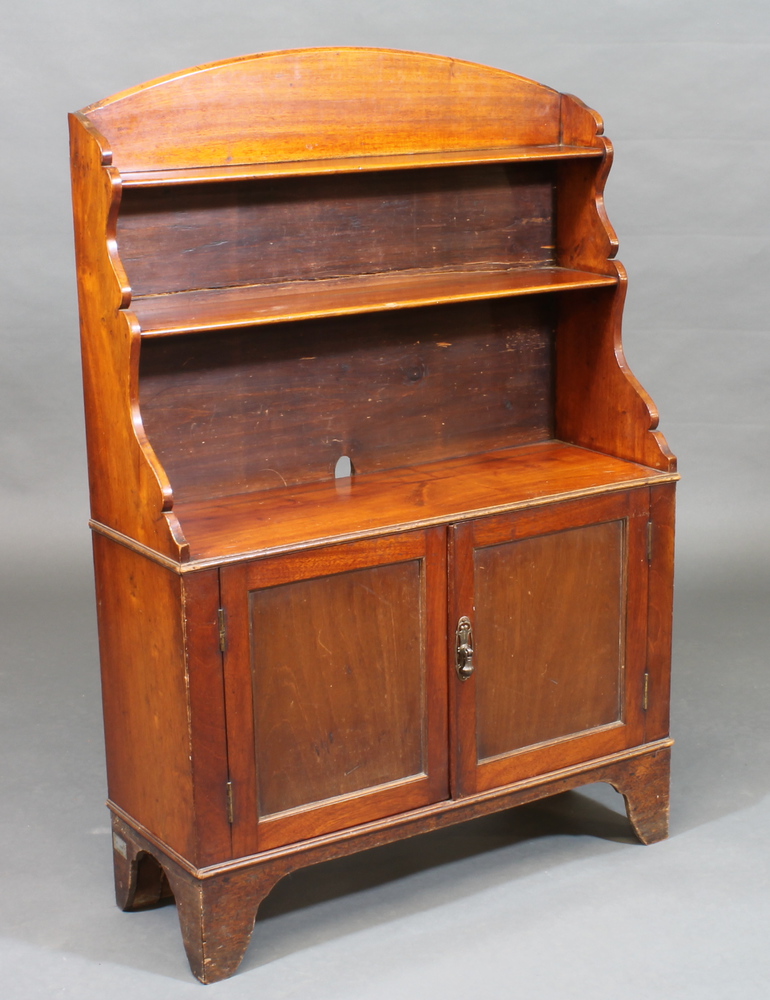 A 19th Century mahogany waterfall bookcase with arch shaped  top, the base fitted a cupboard