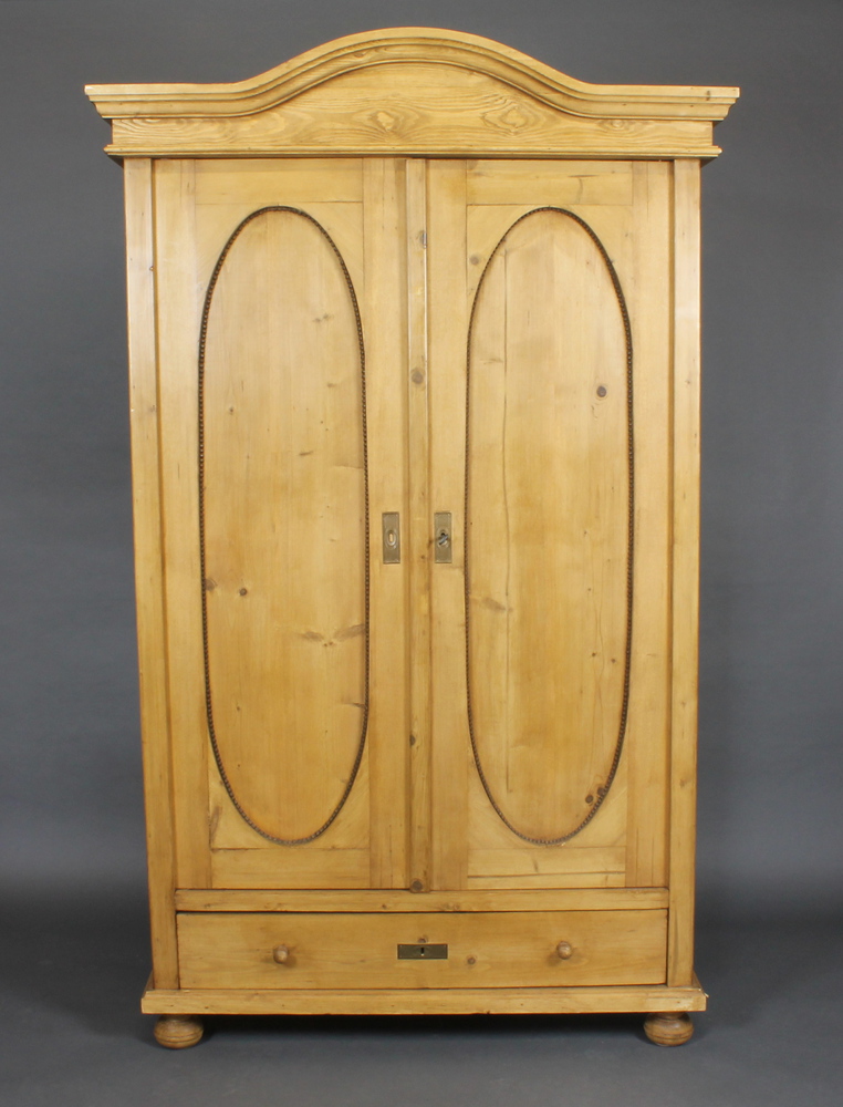 A Continental stripped and polished pine cabinet with moulded cornice, the interior fitted shelves