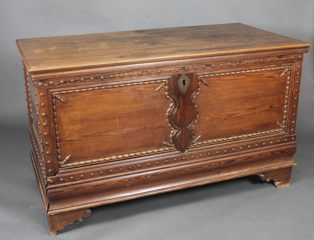 A 19th Century Continental pine coffer with hinged lid the base fitted a secret drawer, raised on