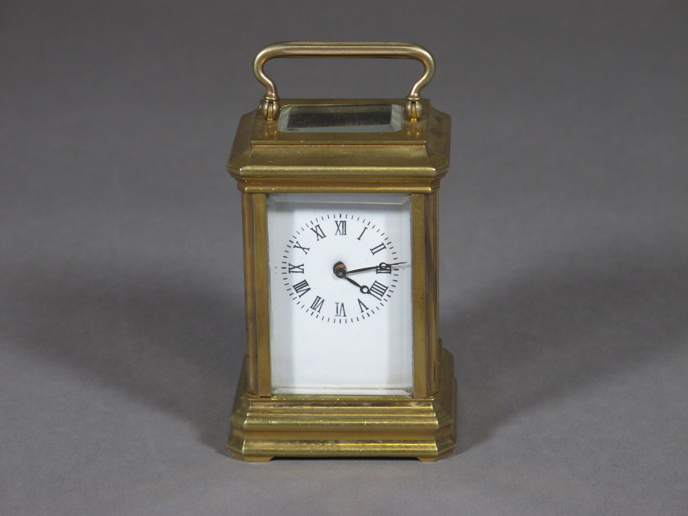 A modern carriage clock with enamelled dial and Roman  numerals contained in a brass case 2"  5