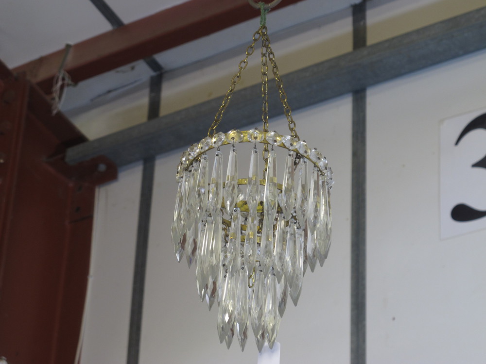 A circular 3 tier drop light ligh shade hung lozenges