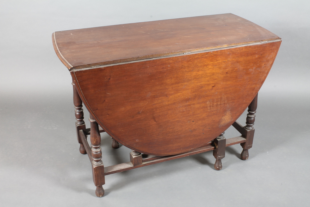 A 19th Century mahogany oval drop flap gateleg dining table  raised on turned supports 42"w x 28"
