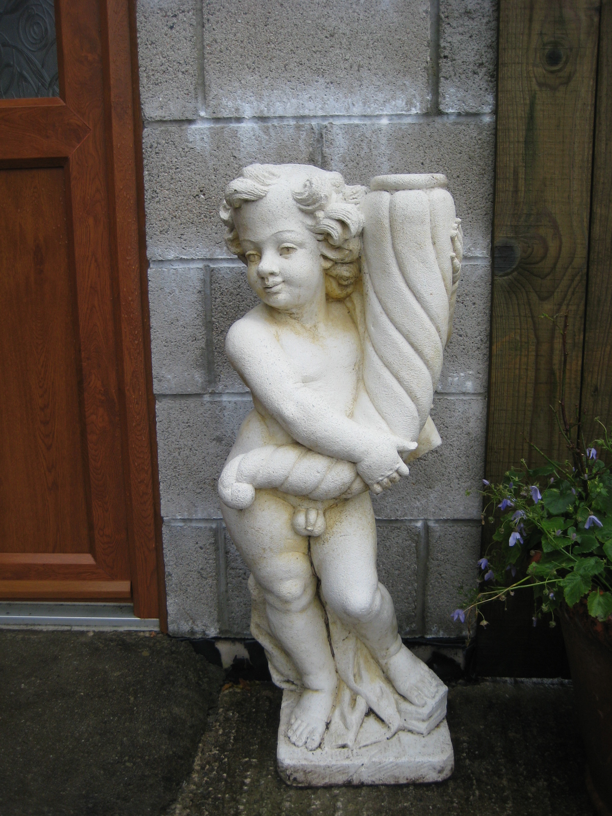 A re-constituted garden statue of a youth with shell