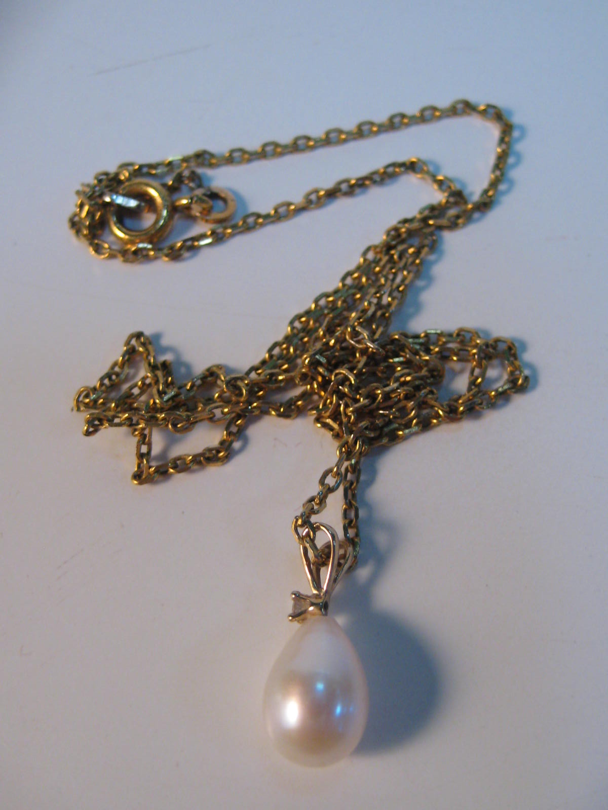 A fine gold chain with pearl and diamond pendant
